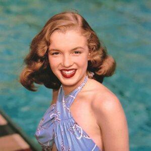 The Lost Photos of Marilyn Monroe: Inside the Pinup Shoot That Changed Everything There are moments in history that only become meaningful in hindsight. In 1946, when a 19-year-old brunette named Norma Jeane Dougherty stepped in front of photographer Richard C. Miller’s camera, no one in the room imagined they were capturing the earliest chapters of an icon. The world didn’t yet know Marilyn Monroe. She wasn’t a superstar, a cultural symbol, or a Hollywood legend. She was simply a young model—hopeful, determined, and unaware of the extraordinary life waiting for her. These rare photographs, now resurfacing decades later, feel like a time capsule. They show Marilyn before the stardom, before the blonde-bombshell image, before history reshaped her identity. This is the Marilyn most people never saw—natural, innocent, and right on the edge of transformation. The Lost Photos of Marilyn Monroe: Inside the Pinup Shoot That Changed Everything The Moment Before Stardom: When Norma Jeane Stepped Into the Frame Richard C. Miller was already a respected photographer when he invited Norma Jeane for a pinup-style shoot in southern California. At the time, the country was transitioning out of World War II, and pinup imagery remained deeply tied to American culture and morale. Yet while most pinup models blended into a familiar aesthetic, Norma Jeane stood out immediately. The Moment Before Stardom: When Norma Jeane Stepped Into the Frame She didn’t just pose—she glowed. Her expressions were soft, genuine, unforced. She held herself with the ease of someone who belonged in front of the camera, even if she didn’t know it yet. With her dark curls, bright smile, and playful confidence, she brought a freshness to the images that few models of the era could replicate. Miller later said she was simply “a sweet, ambitious young woman”—but even he admitted he couldn’t have predicted how famous she would become. Richard C. Miller was already a respected photographer when he invited Norma Jeane for a pinup-style shoot in southern California And if you want to glimpse the woman behind the legend, the voice behind the photographs, don’t miss this rare 1960 interview — a moment where Marilyn Monroe quietly admits, ‘I’m generally miserable,’ revealing a truth far more human than the myth ever allowed. https://youtu.be/heQaJPFP5gU A Photographer’s Discovery: Capturing a Natural Talent Without Knowing Her Future Miller often worked with new talent, but there was something undeniably magnetic about Norma Jeane. She didn’t need elaborate lighting or dramatic backdrops; her presence carried the frame. She instinctively knew how to shape a pose, soften her gaze, tilt her head just enough to make the still image feel alive. She didn’t need elaborate lighting or dramatic backdrops; her presence carried the frame. This wasn’t technical training—it was natural instinct. During the shoot, Miller noticed her ability to shift moods effortlessly. One moment she looked shy, almost girl-next-door. The next, she radiated subtle glamour, hinting at the star she would eventually become. He later admitted that if he had realized what she would grow into, he might have taken even more care to document the moment. But at the time, it was just another modest assignment—one that history would later elevate into a priceless collection. The Images That Survived Time Today, the surviving photographs from that session stand as some of the most intimate early images of Marilyn Monroe ever recorded. They reveal a version of her untouched by Hollywood’s reshaping hands. A young Norma Jeane floating effortlessly in clear green water during one of her earliest outdoor photoshoots, radiating calmness and natural charm. Norma Jeane in a delicate bridal portrait, wearing her first wedding dress—a rare early image capturing her innocence long before worldwide fame. A vibrant beach portrait of teenage Norma Jeane posing playfully in a striped two-piece swimsuit, showcasing her early confidence in front of the camera. Norma Jeane smiling brightly while emerging from the water, her hair pinned up in soft curls—an image that highlights her youthful glow and effortless warmth. A sunlit seaside photo of Norma Jeane sitting on a rock in a white swimsuit, capturing the carefree spirit of her earliest modeling days. Norma Jeane stepping out of a swimming pool in a classic white bikini, offering a glimpse of the poise that would later define her on-screen presence. A cheerful moment of Norma Jeane playing at the shoreline, laughing as waves crash around her—one of the most iconic images from her early pinup-style sessions. Norma Jeane dressed in a gingham blouse and denim jeans, posing by a wooden fence in a countryside setting—a reminder of her humble, wholesome beginnings. Each image offers a different shade of the young woman she was—before fame sculpted her into a symbol. From Quiet Modesty to Cultural Icon: Why These Photos Matter Today These photographs matter not just because Marilyn Monroe became a global icon, but because they remind us of her humanity. Long before she was the face of films, magazines, and pop culture fantasies, she was Norma Jeane—a young woman navigating uncertain dreams. These photographs matter not just because Marilyn Monroe became a global icon, but because they remind us of her humanity Her early images show a softness seldom associated with the hyper-stylized Marilyn persona. They bridge the gap between girlhood and womanhood, revealing the gradual evolution of someone who would eventually redefine beauty standards. More importantly, the photos highlight something timeless: authenticity. Her innocence feels real, not performed. Her confidence feels emerging, not manufactured. The world later saw Marilyn Monroe as a constructed figure; these photos reveal the woman behind that construction. Collectors, historians, and fans continue to revisit these images not for nostalgia alone, but because they offer a rare, unfiltered truth—one that still resonates in a world obsessed with polish and perfection. Heading to Auction: The Legacy and the $80,000 Time Capsule The original 1946 photographic model release form signed by Norma Jeane Dougherty, granting photographer Richard C. Miller permission to use her images—an early document from the beginning of her modeling career. On October 7th, the entire collection was set to be auctioned at Santa Monica Auctions, with expected bids ranging from $60,000 to $80,000. For collectors, this isn’t just memorabilia—it’s history. It’s a tangible link to the moment Marilyn Monroe first stepped into her destiny. Richard C. Miller, who passed away in 2010 at age 98, never lived to see the modern fascination with these early images. But his work remains an essential part of Marilyn’s visual legacy. His photographs capture not the myth, but the beginning of the story. And that is why they are priceless. These rare photographs remind us that before Marilyn Monroe became an icon, she was a young woman standing at the threshold of a life she could not yet imagine And if these rare photographs show us the beginning of her story, this video reveals the part the cameras could never fully capture — the fragile, turbulent life behind Marilyn Monroe’s radiant smile. Watch to understand the woman the world adored but never truly knew https://youtu.be/A9RThZnYV0g Final Thoughts: A Glimpse Into Who She Was Before the World Knew Her These rare photographs remind us that before Marilyn Monroe became an icon, she was a young woman standing at the threshold of a life she could not yet imagine. The images allow us to meet her not as a legend, but as Norma Jeane—hopeful, radiant, and beautifully human. In a world where celebrities often appear fully formed, these photos show the quiet beginning of someone who would one day illuminate the screen like no one else. They offer a simple yet powerful truth: every icon has an origin story. And sometimes, that story starts with a single camera, a quiet afternoon, and a young woman destined for immortality.